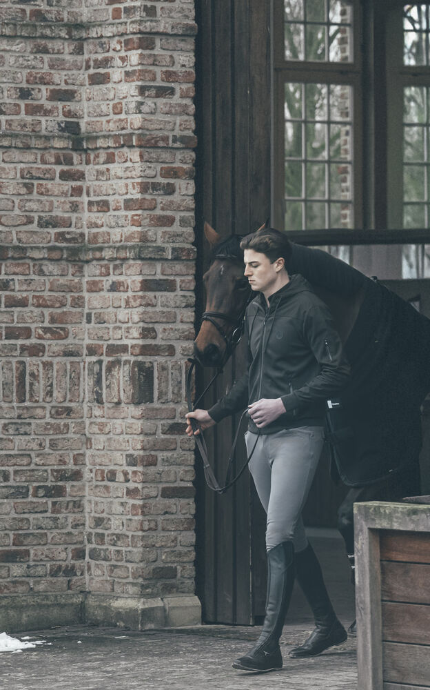 Pikeur Steppjacke mit Reithose vor Backsteinmauer